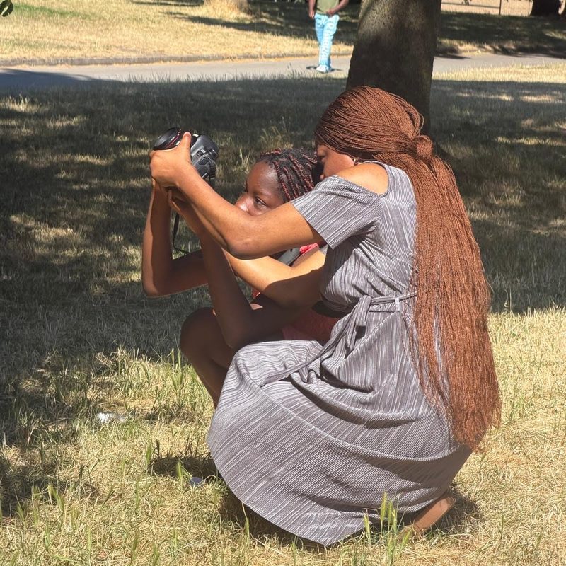 Two children sharing a camera during the photography workshop