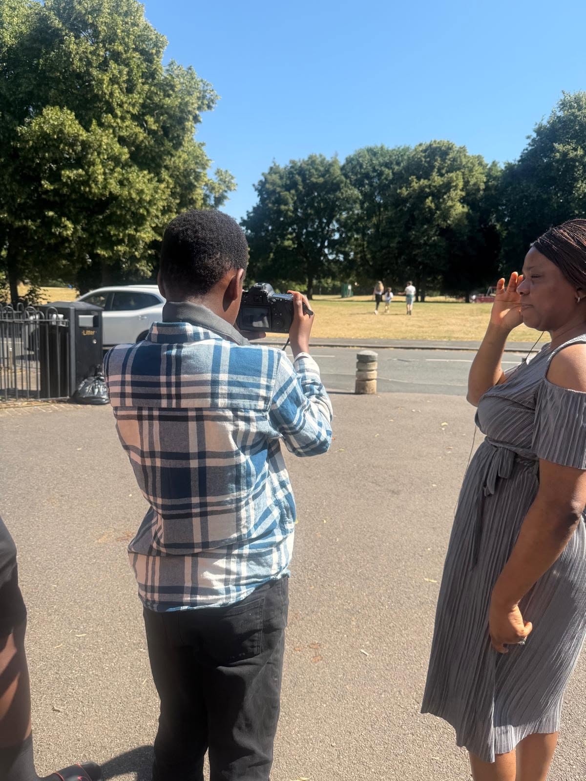 A young photographer takes a portrait of Aunty Kikelomo in the park